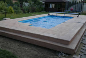 Bazénový lem a dlažba u bazénu vytváří odpočinkovou terasu.