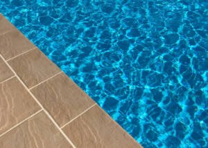 Pohled na bazénový lem Rovný s okolní dlažbou z betonu Mystery