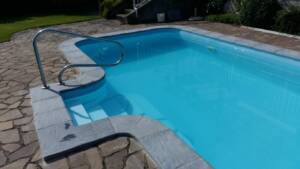 Bazén s okolním lemováním betonovou lemovkou šedé barvy